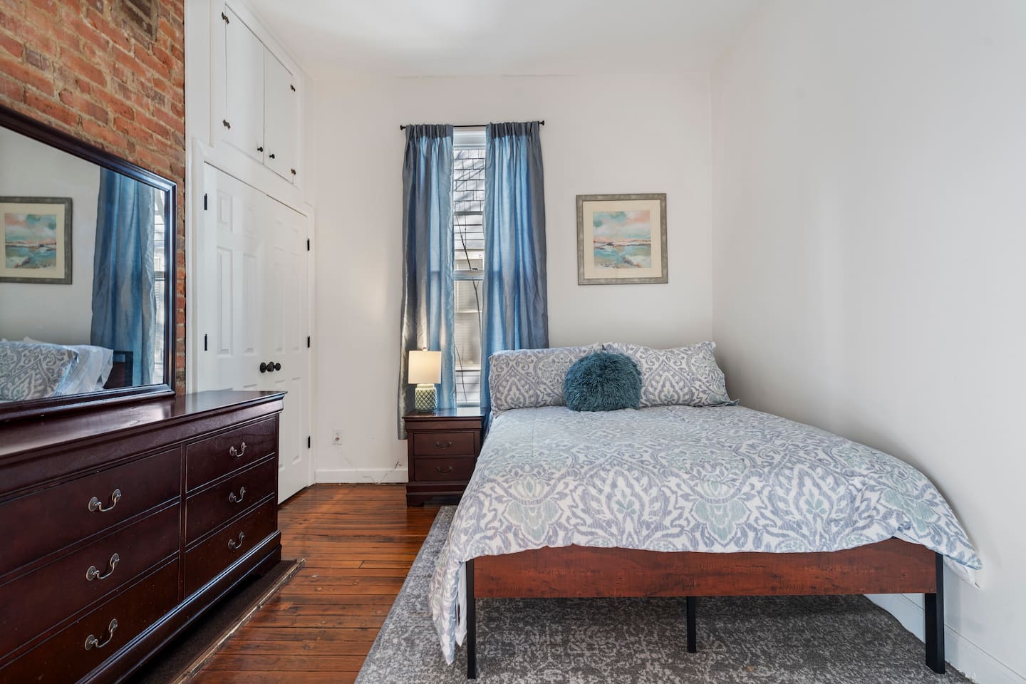 Second queen bedroom — bright, comfortable, with original hardwood floors