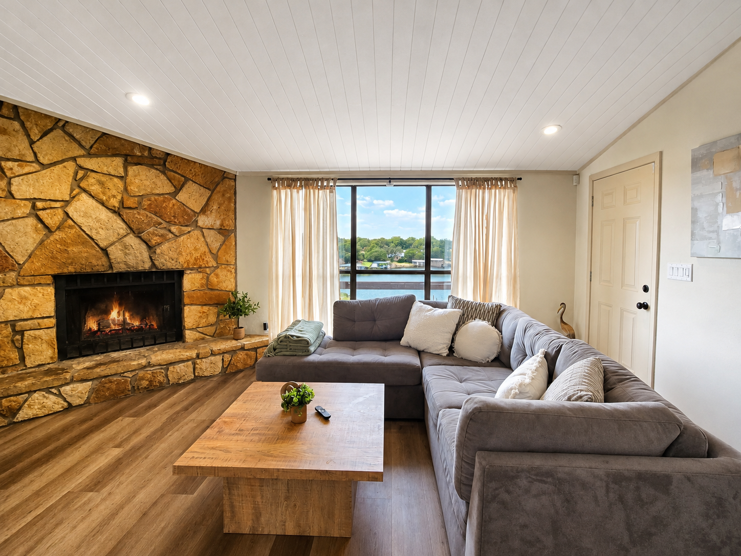 Open living room with fireplace and panoramic lake views.