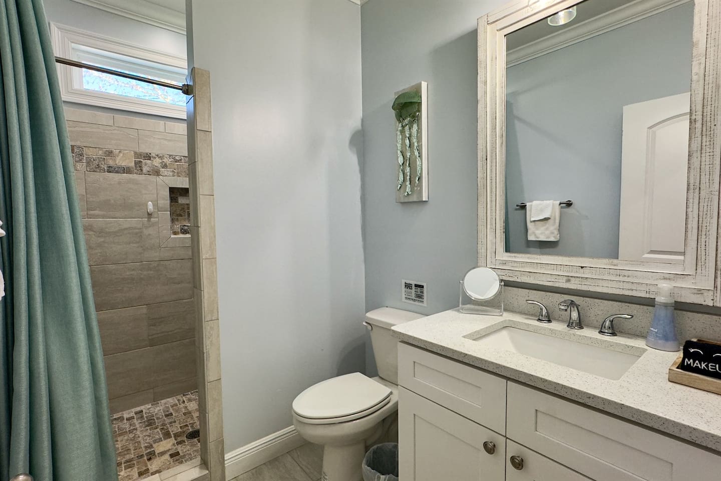 Fresh, spa-style bathroom with a walk-in shower, elegant vanity, and soothing coastal tones.