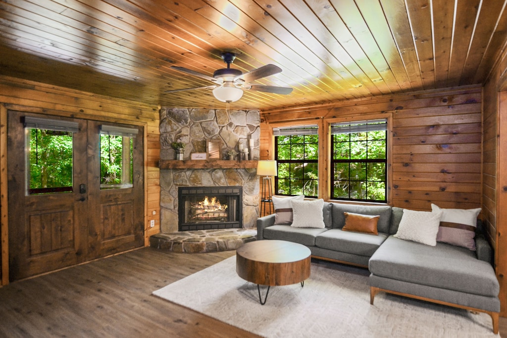 Inviting living room w/ L shaped couch and wood burning fireplace 