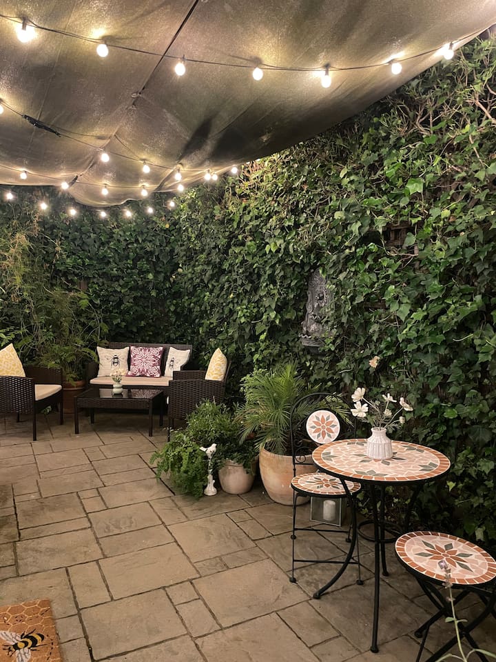 Peaceful backyard with warm string lights and fountains, perfect for relaxing in the evening.