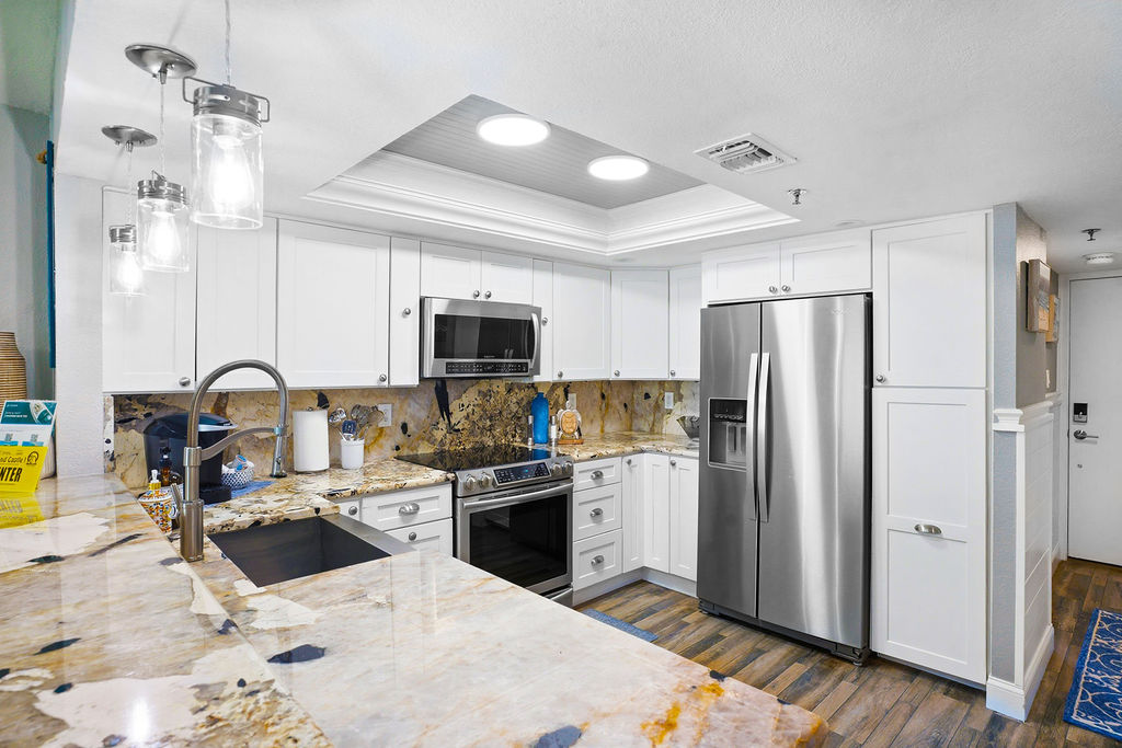 Fully equipped modern kitchen in this beachfront vacation rental featuring stainless steel appliances and spacious countertops for effortless vacation dining.