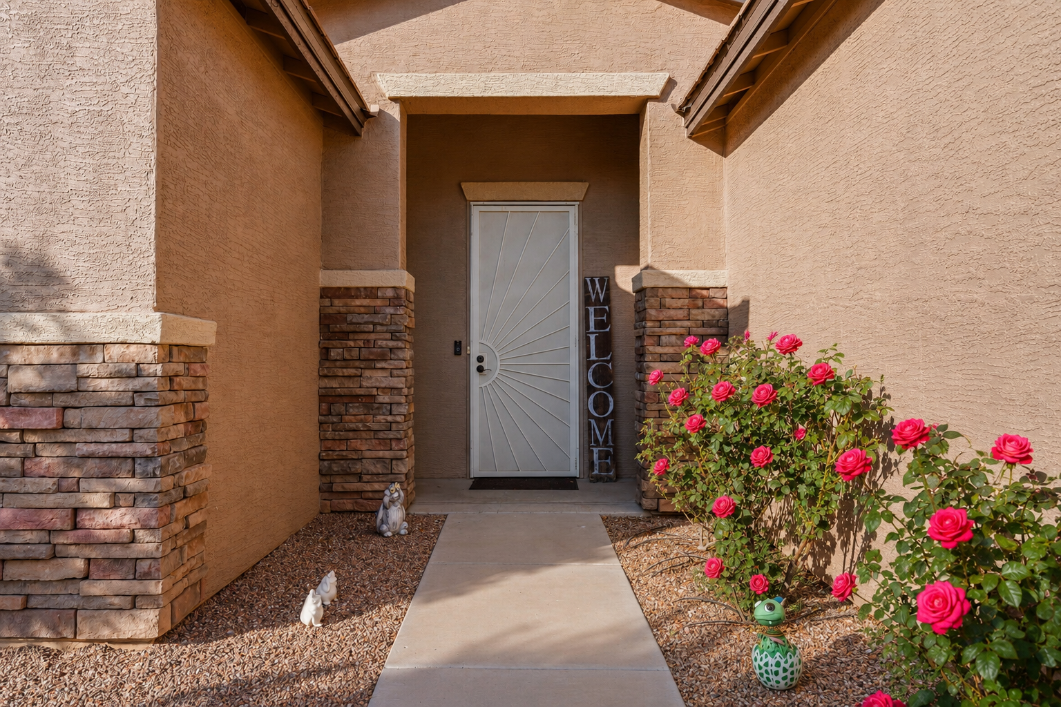 Welcoming entry with blooming desert roses and easy self check-in