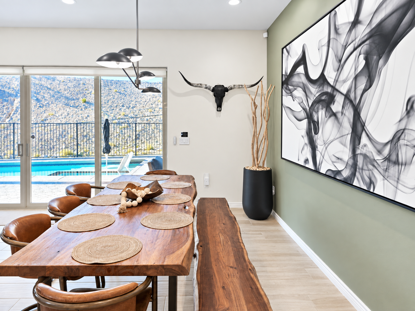 Custom live edge wood dining table with seating for 8 and dramatic Restoration Hardware light fixture creating a sophisticated focal point.
