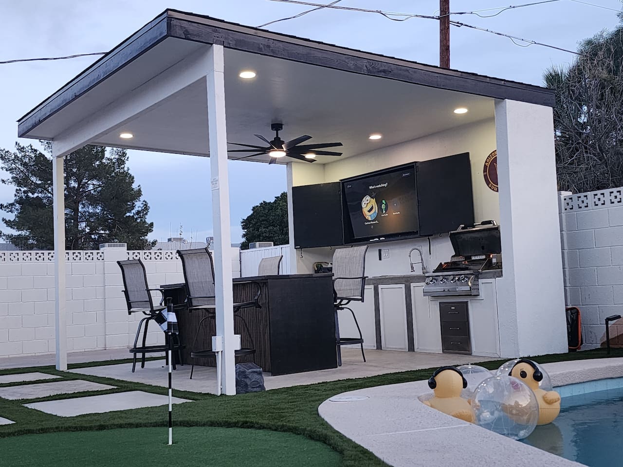 Our large gazebo with bar seating, built-in grill, sink and mini fridge is perfect for a beer or cocktail, dining, and relaxing. Enjoy your favorite movies, shows or sports on the 65" TV, which features free Peacock streaming.