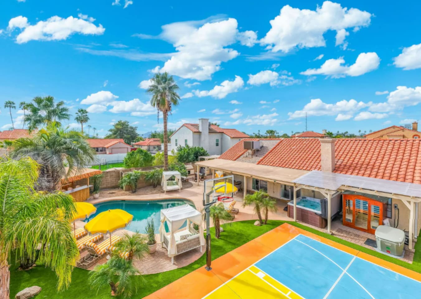 Expansive backyard resort with pool, spa, basketball court, and lush landscaping—an entertainer's dream with desert views.