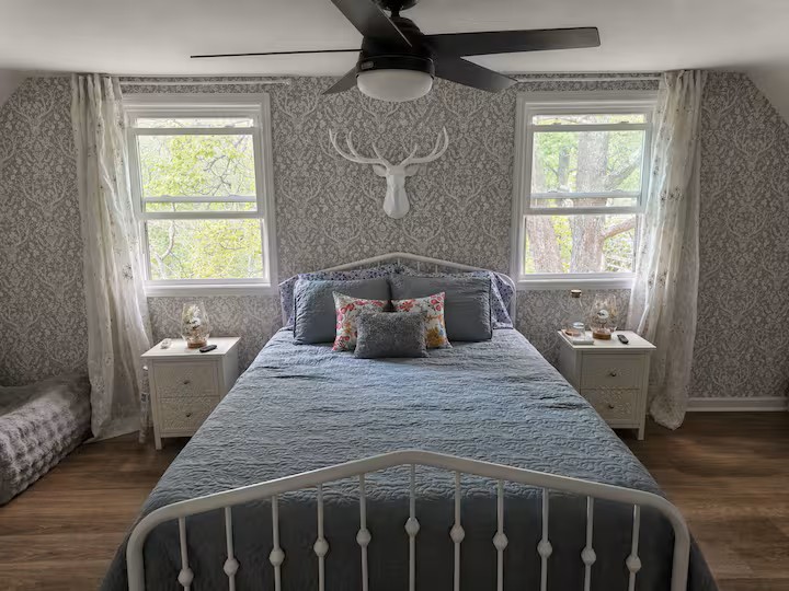 Charming second-floor primary bedroom with a queen bed, natural light and a cozy retreat feel near the upstairs loft and deck.