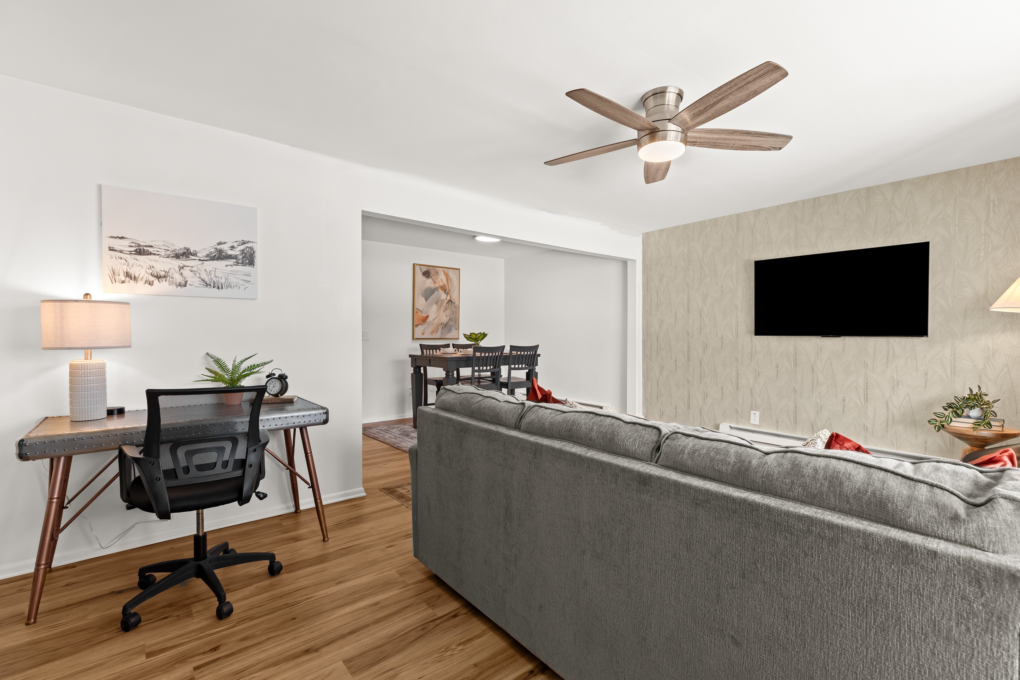 The desk setup sits conveniently between the living and dining areas for easy access and seamless flow.