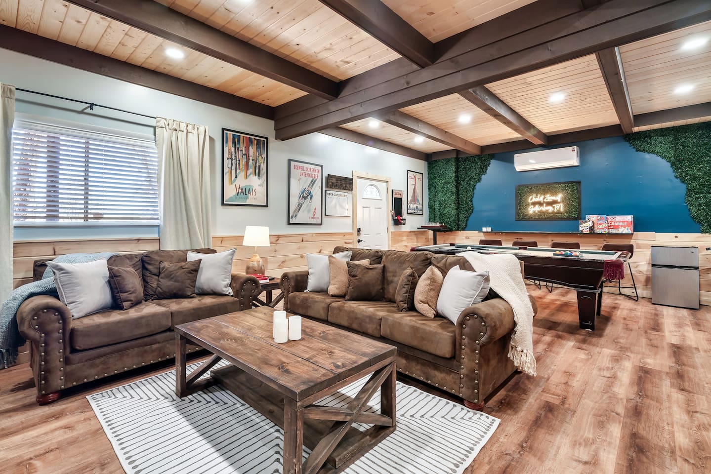The lower level basement, with an exterior access door features 75" smart TV, pool table, ping-pong table topper, mini fridge, cornhole boards, 2 arcade games, a pull-out sofa bed, and a wood-burning fireplace. Plus a full bathroom on this level.