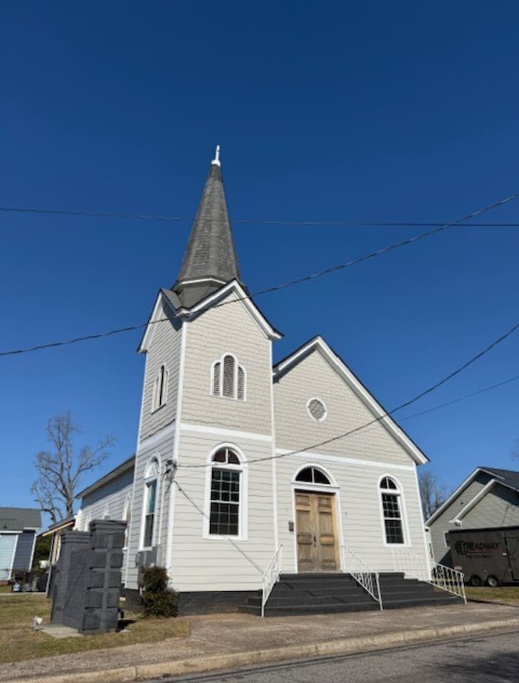 Charming historic church façade with traditional white siding and a signature steeple. Ideally situated near Downtown Augusta hotspots, the Medical College of Georgia, and local event venues. Generous on-site parking makes arrival easy.