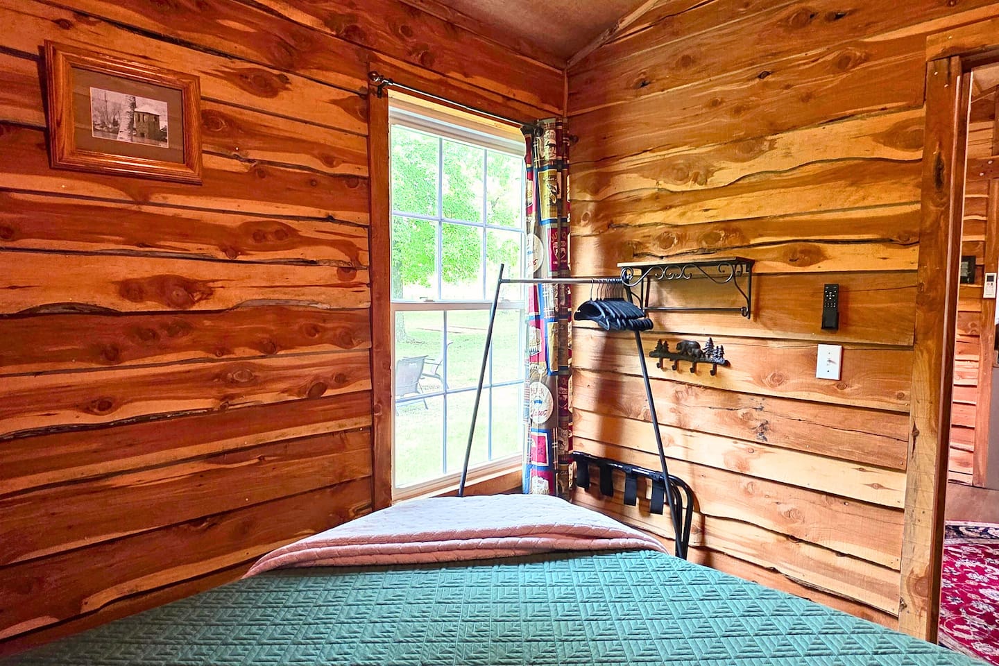 Drift off to sleep in the peaceful cabin bedroom, complete with cozy lighting, ceiling fan, rustic charm, and nature views right outside your window. 