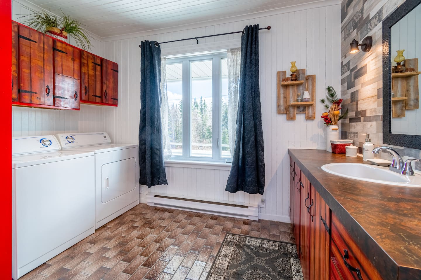 Salle de bain complète avec un bain-douche, laveuse, sécheuse et lavabo. Elle est situé au rez-de-chaussée.