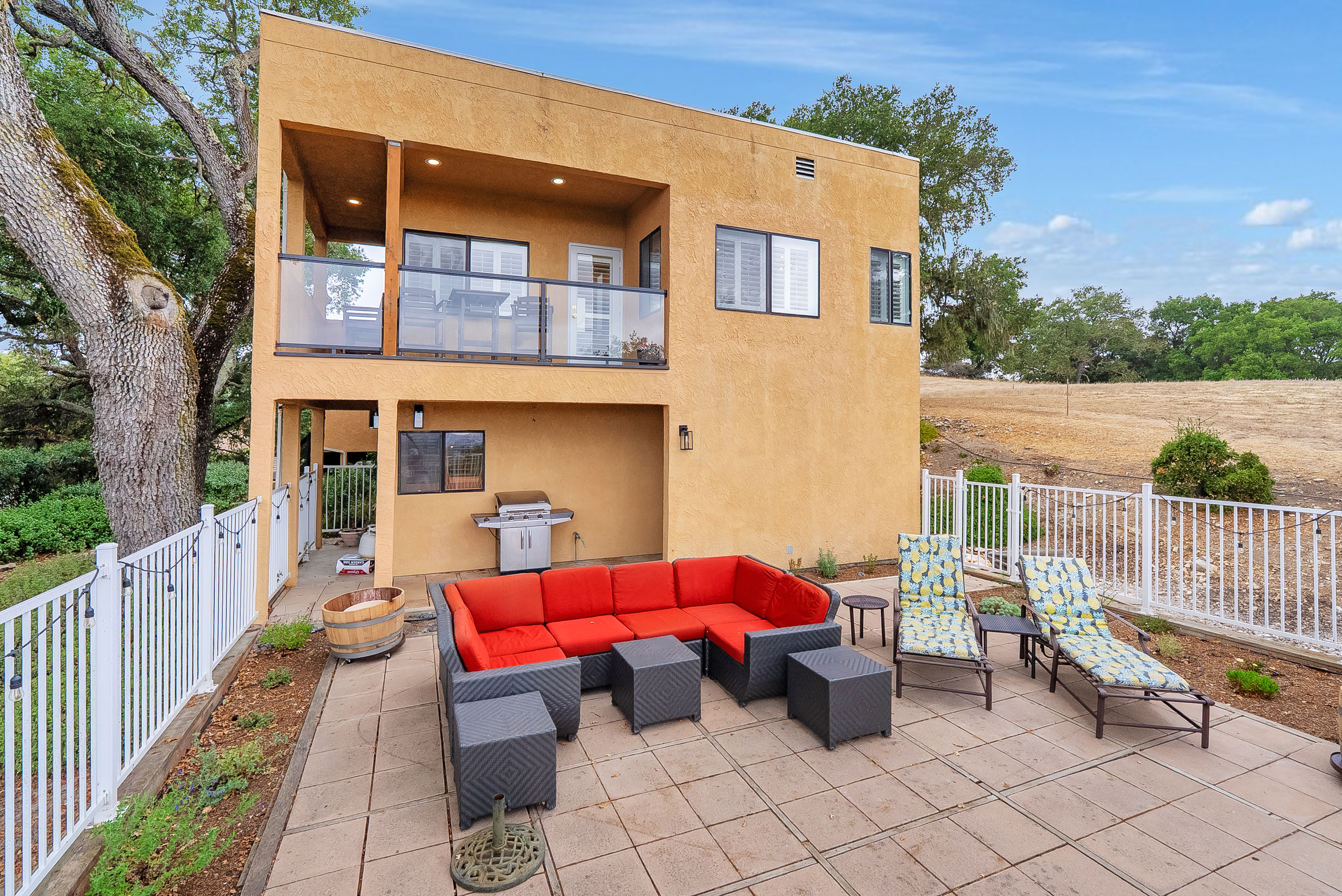 This stunning modern property offers multi-level outdoor enjoyment, featuring a spacious upper balcony off the main level and a lower, private patio perfect for grilling and lounging.