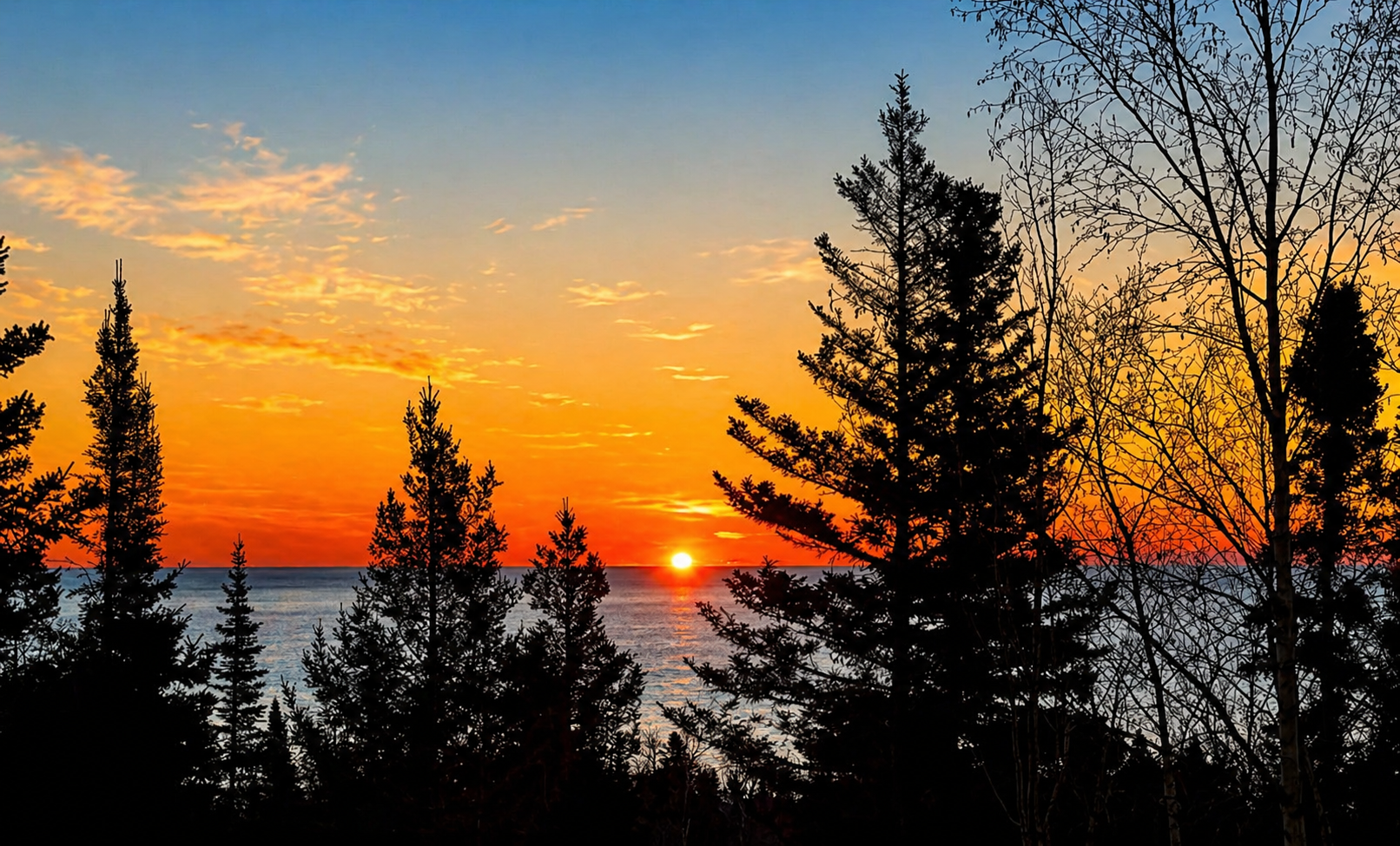 Wake up slowly at Treetops and step out onto the deck with a warm cup of coffee in your hand as the sun begins to rise over Lake Superior. The first light peeks through the trees, glowing softly between the branches before spilling out across the water.