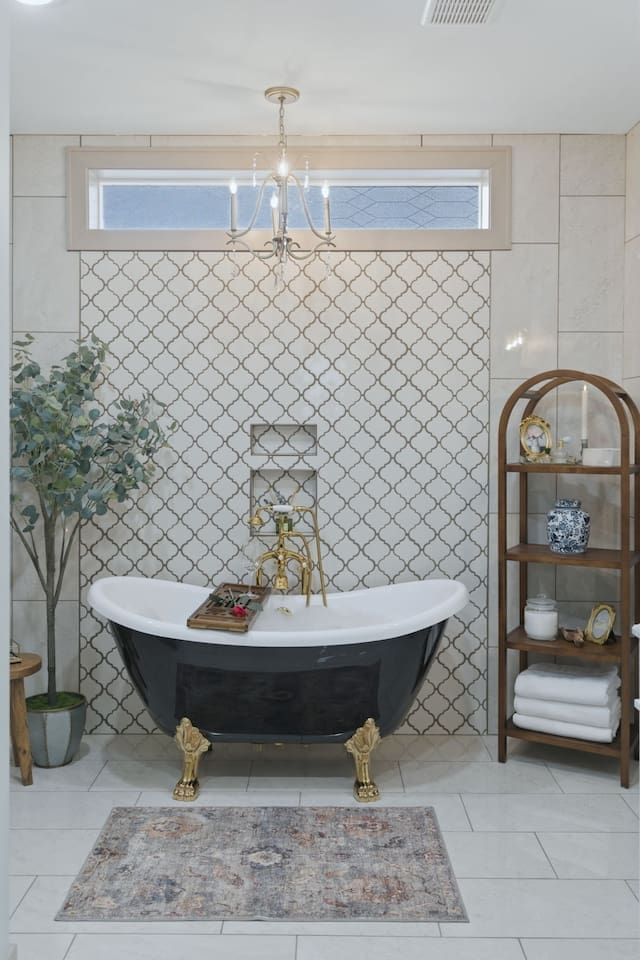 Beautifully styled bathroom with a classic clawfoot tub, elegant chandelier, and thoughtful touches for a relaxing, upscale retreat
