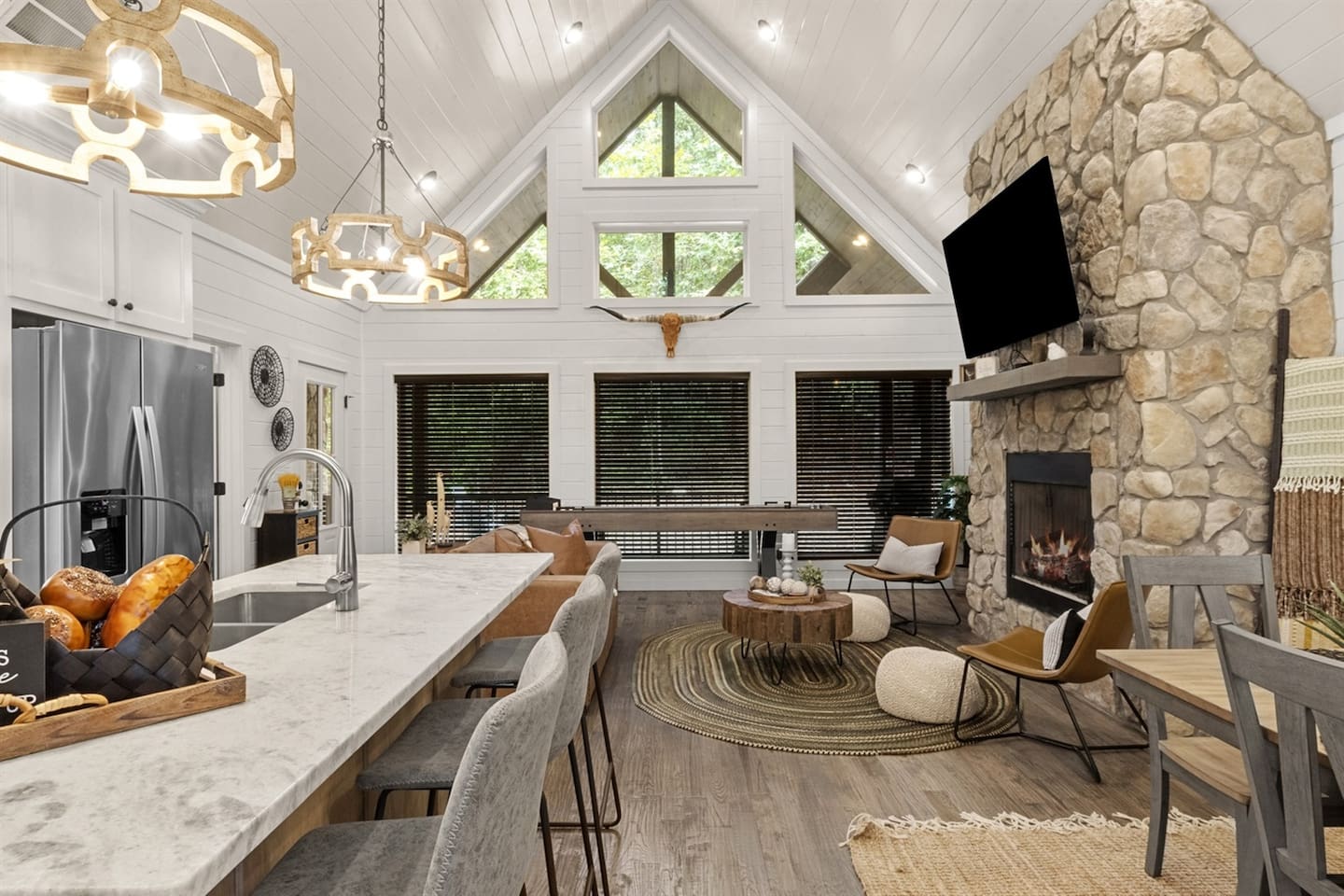Granite countertops and stainless steel appliances blend seamlessly with a cozy gas fireplace and shuffleboard table for relaxed evenings indoors.