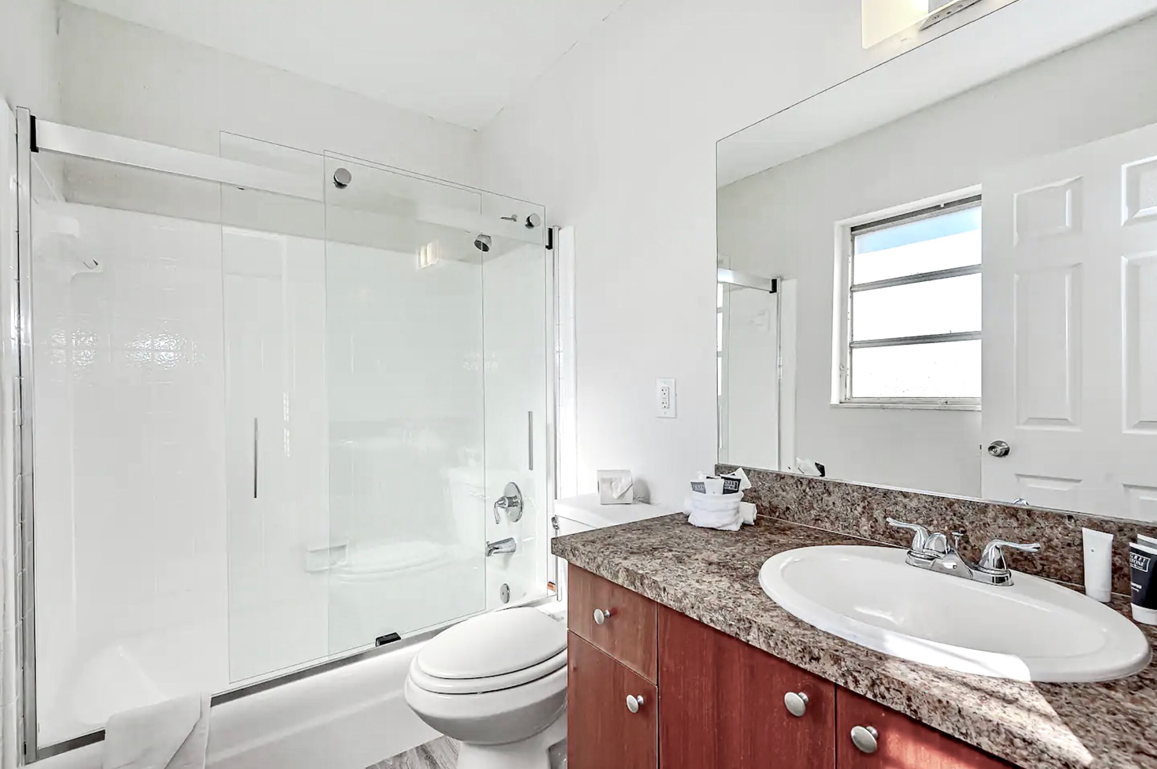Bathroom with tub/shower and sliding glass door.
