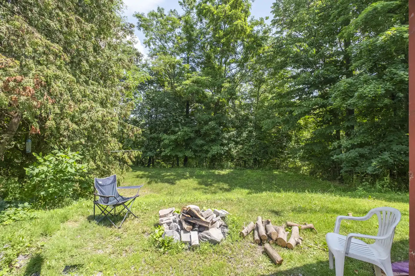 Firepit area surrounded by trees and outdoor seating
