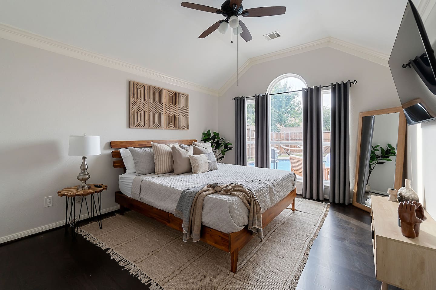 Embracing luxury and comfort in this spacious bedroom, where a king-size bed beckons amidst plush cushions. While glass window reveals a breathtaking view of the backyard pool area, creating a perfect blend of comfort and serenity.