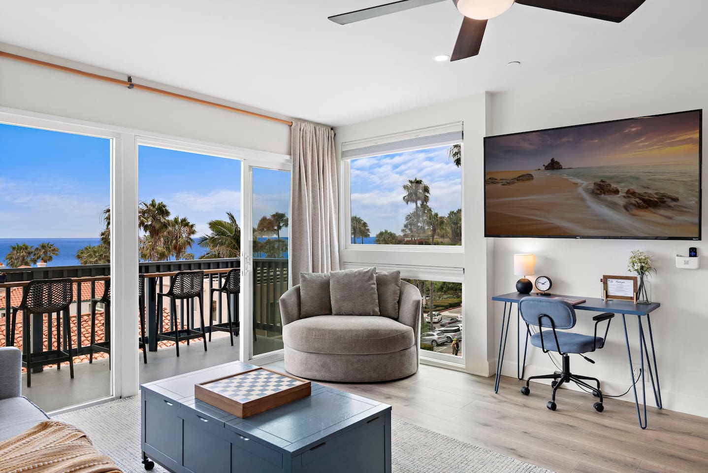 The living room has lots of comfortable seating, views and natural light pouring in from the balcony.