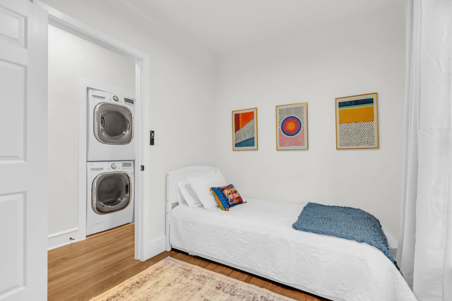 Cozy bedroom with single trundle bed that pulls out into another single bed, warm lighting, and colorful accents.
