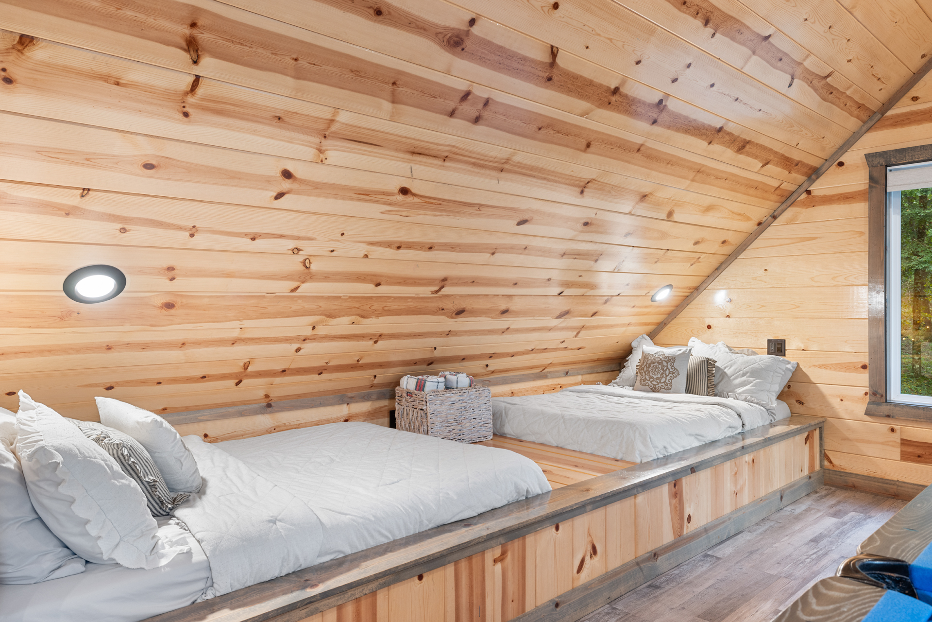 Cozy loft sleeping area tucked beneath warm wood ceilings