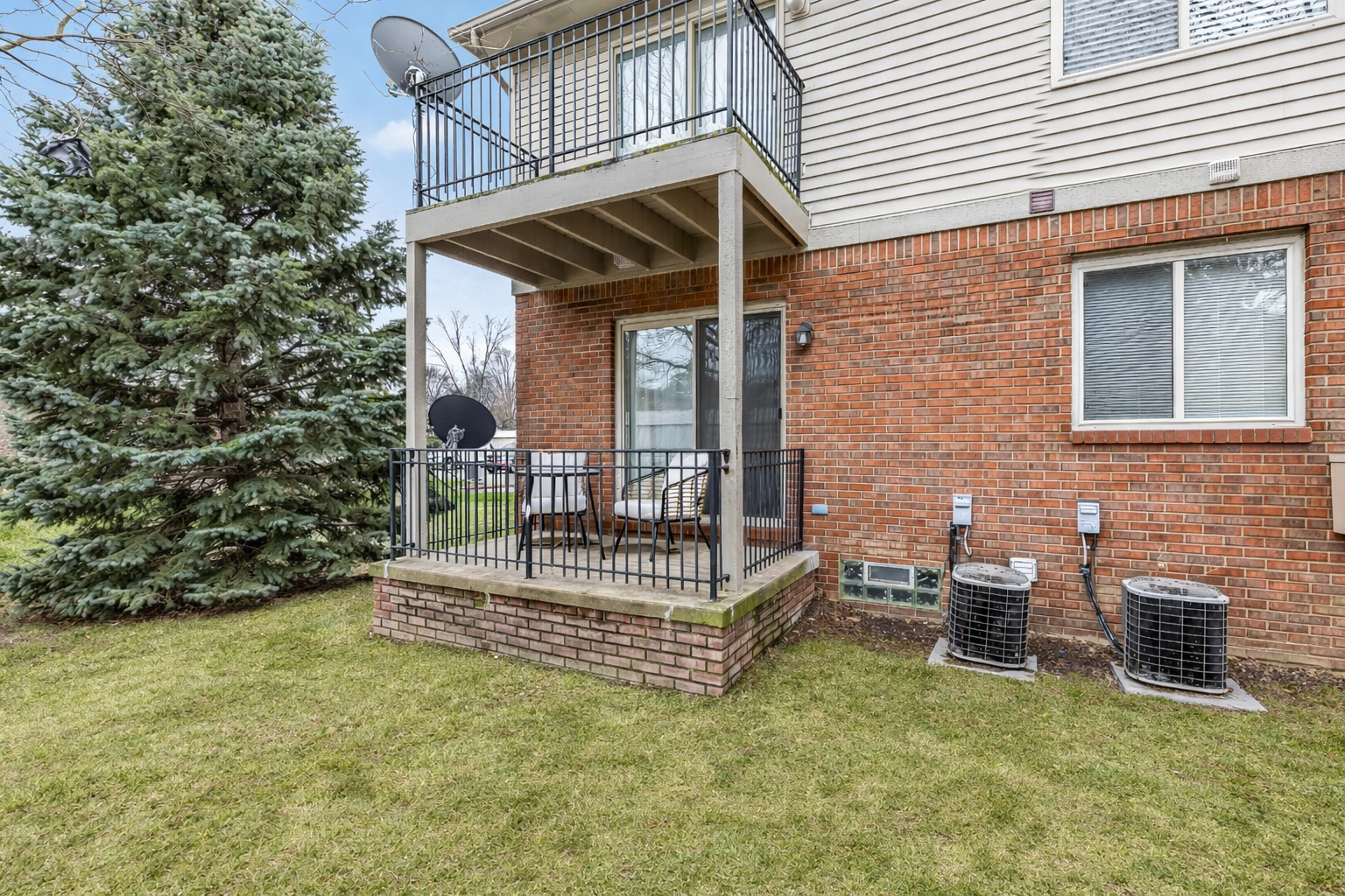 Enjoy a private patio in a peaceful condo setting, surrounded by green space and perfect for relaxing outdoors.