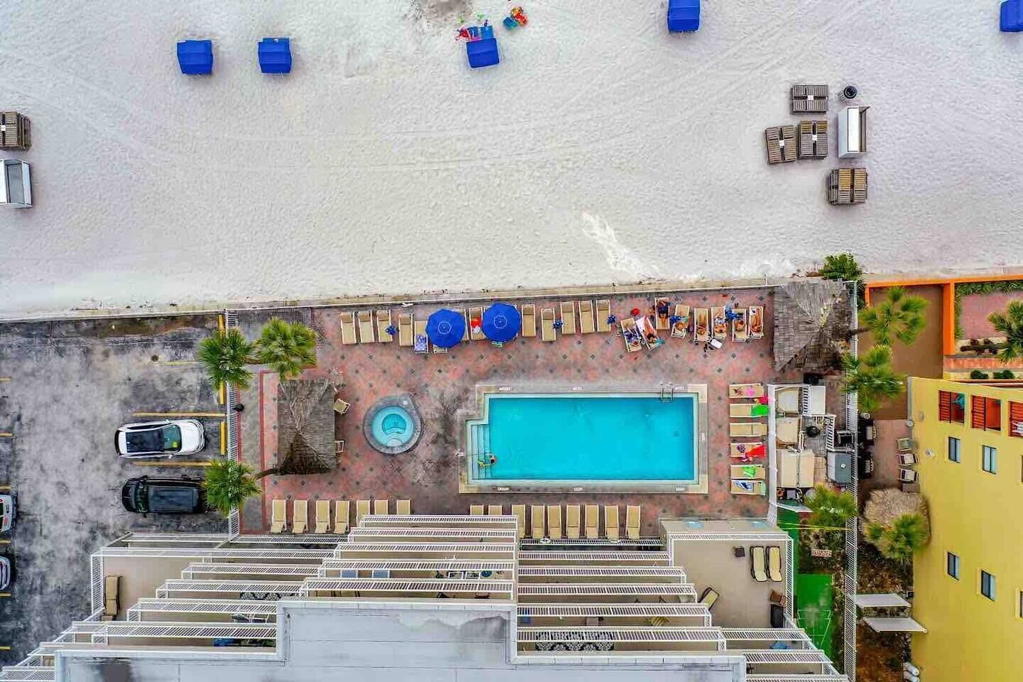 View of the pool, hot tub, loungers, outdoor shower and gas grill