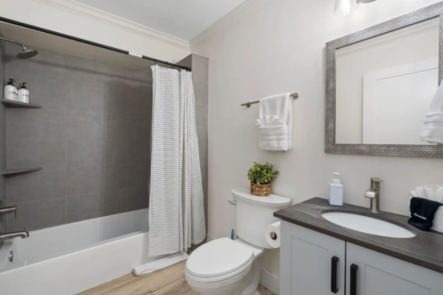A classic tub-shower combo makes this bathroom easy for families, with fresh towels and a tidy vanity keeping everything feeling well cared for.