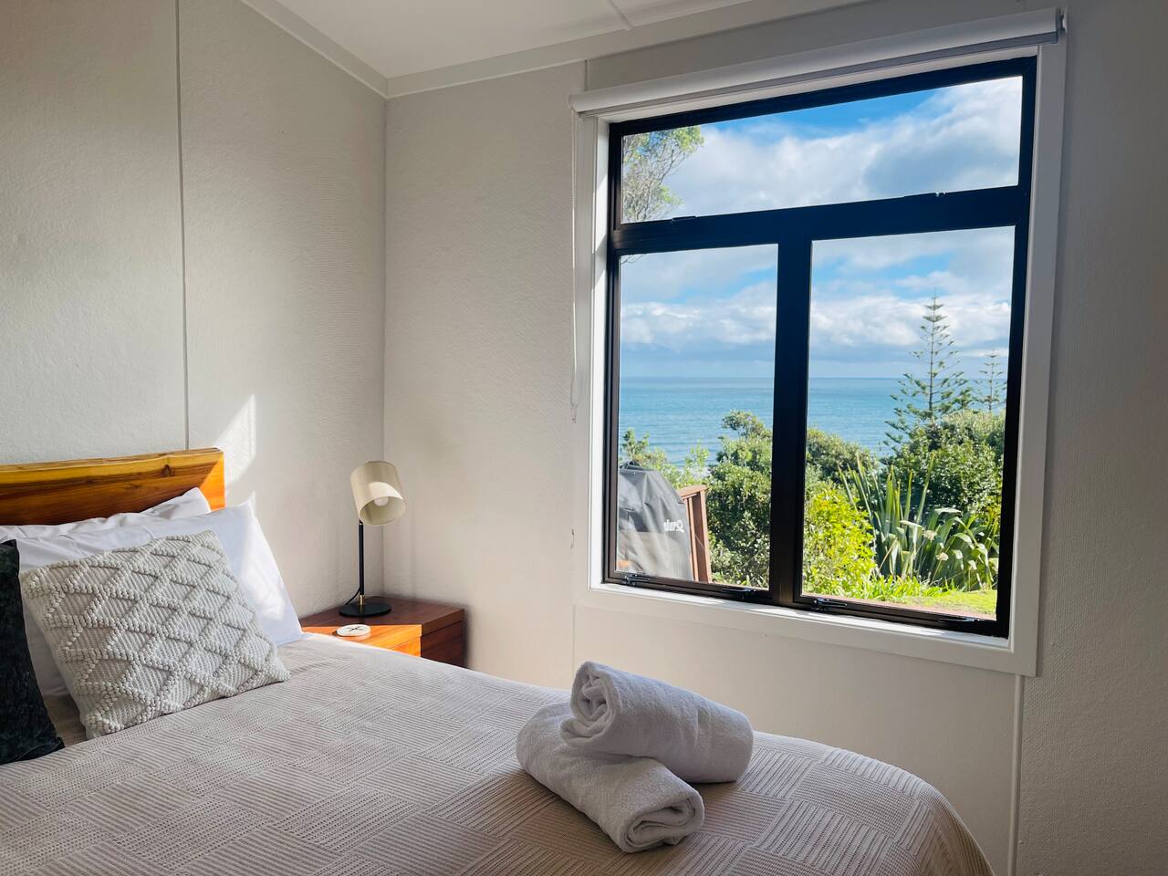 Bedroom 1 has a generous queen bed with a comfy memory foam mattress topper, bedside table lamps for that cozy bedtime read, amazing views out to Kapiti Island, a smart T.V. and an eco heater to keep you warm and snug in winter.