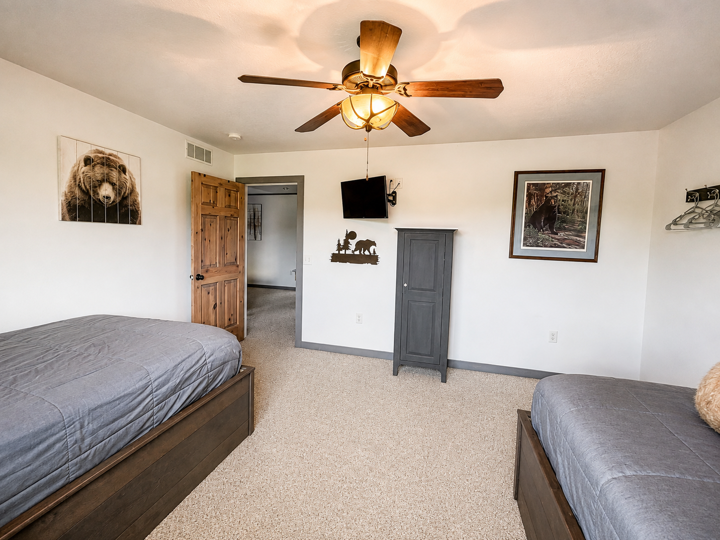 A second view of the bedroom highlights the wall-mounted TV, perfect for winding down with a favorite show after a full day of Northwoods adventures before settling in for the night.