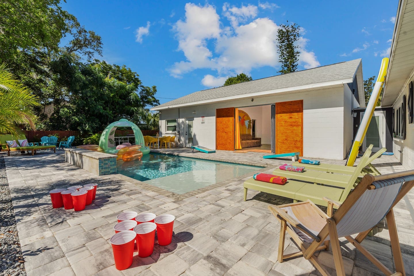 soak up the south Florida sun while watching the 150-inch LED TV through the massive slider door, surrounded by tropical landscaping by the heated salt water pool with LED waterfall, Funboy floats, cornhole & bucketball games, and smokeless firepit. 
