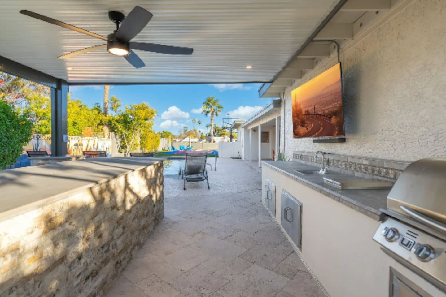 The outdoor kitchen opens right up to the pool, so cooking and swimming never have to happen far apart.