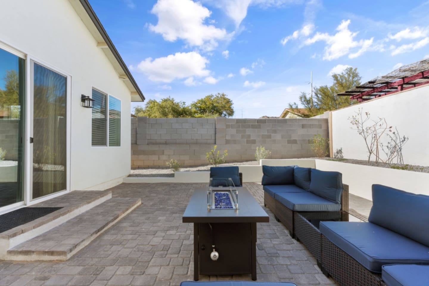 Outdoor living space with comfortable seating, grill, and a fire pit table for evening downtime.