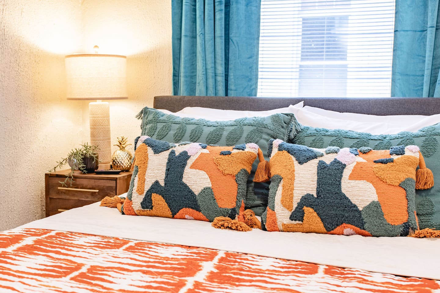Bohemian-inspired bed with colorful, textured pillows, creating a cozy and artistic atmosphere that's perfect for relaxing and unwinding.