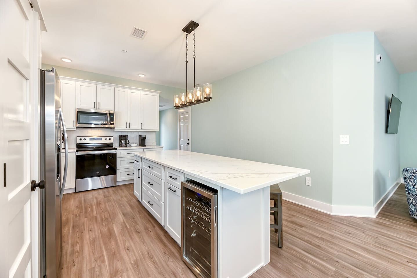 Spacious kitchen layout with oversized island seating and added wine refrigerator for entertaining.