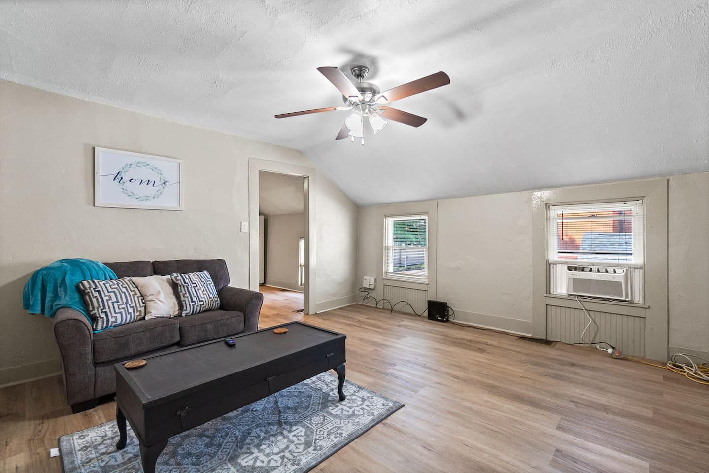 Bright living room with natural light and ceiling fan.
