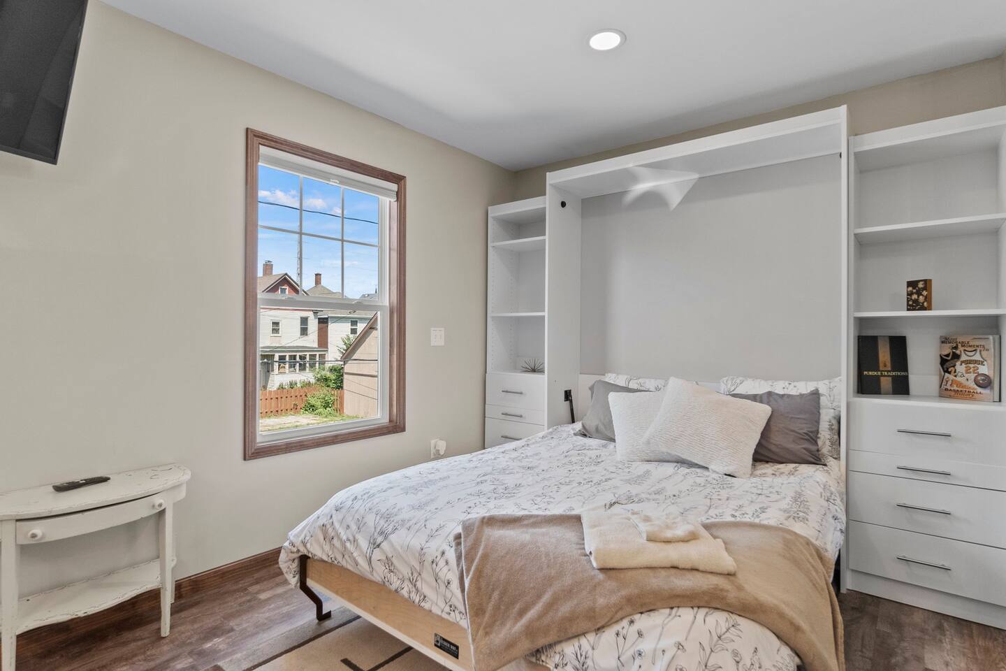 Comfortable queen-sized bed with a beautiful window view, offering a peaceful setting for rest and relaxation.