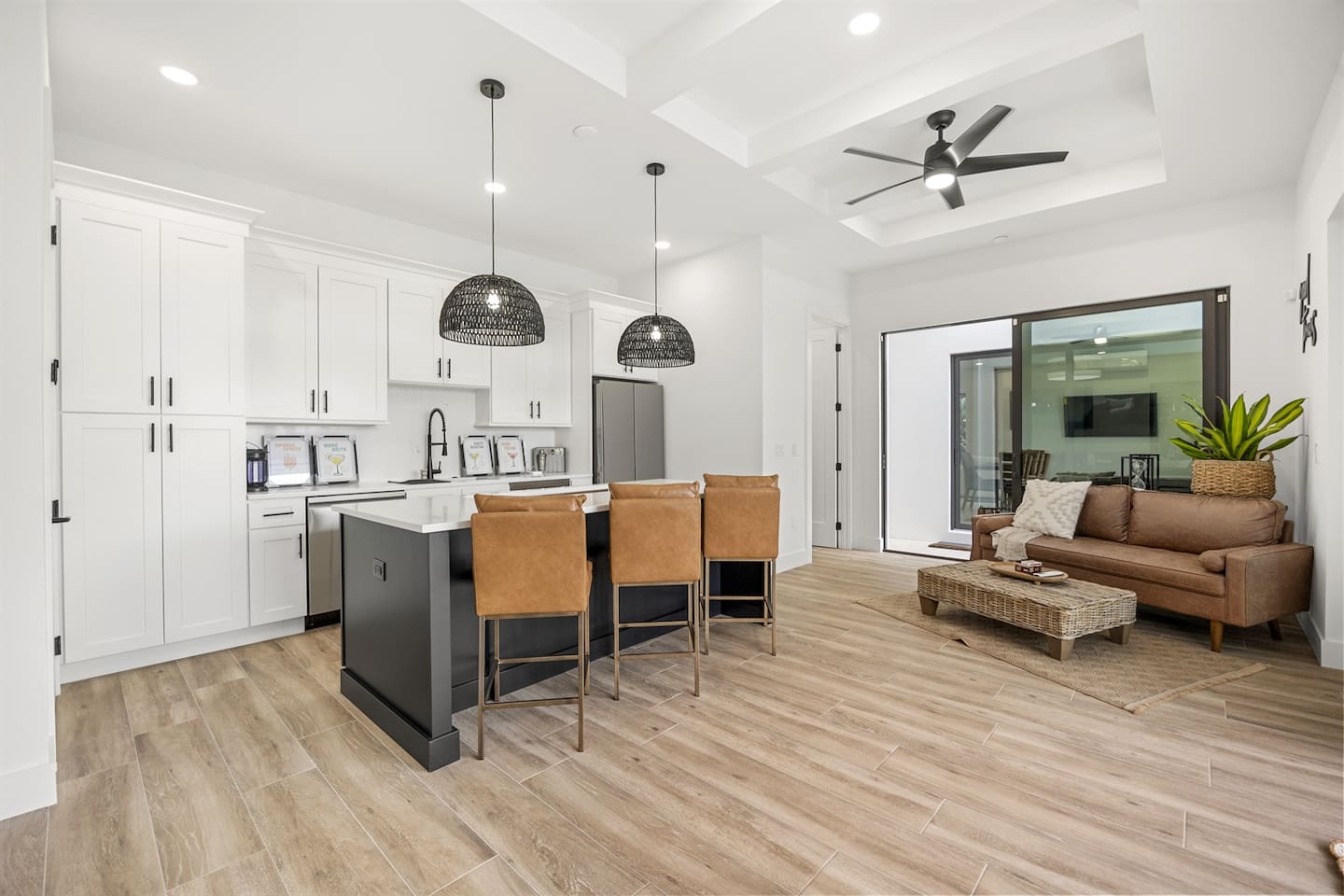 Experience the luxurious event room featuring a chandelier fan, wide-screen TV, stylish table with lit countertop, elegant chairs, a refrigerator, beautiful drawers, comfortable decorated sofa, elegant flooring, perfect for gatherings and relaxation