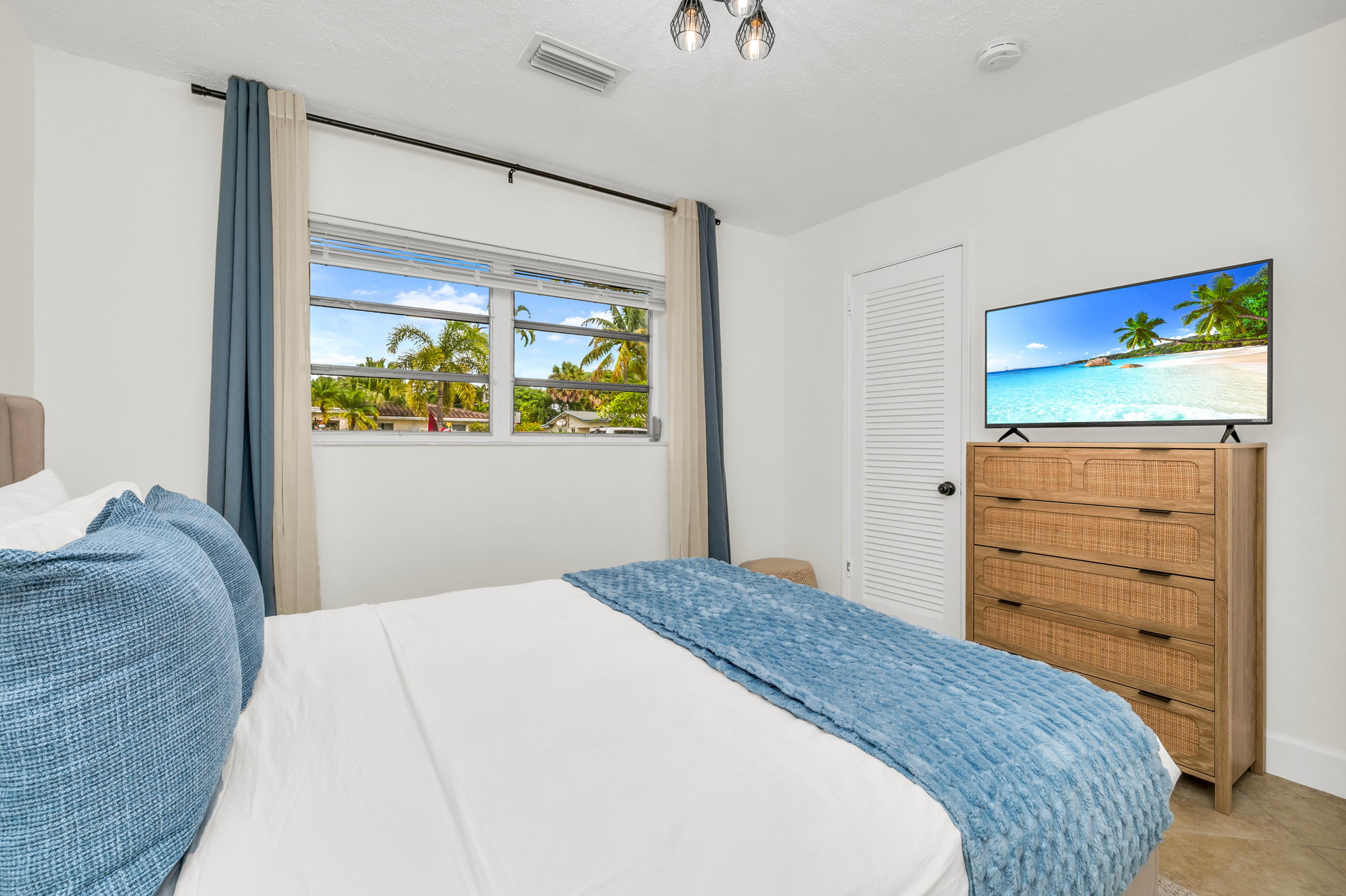 2nd Bedroom: A bright and welcoming retreat featuring a plush queen bed, soft layered linens, and coastal-inspired décor. This room offers ample storage, and warm natural light.