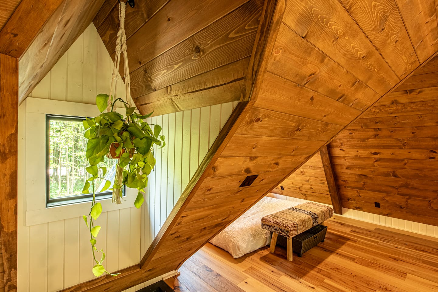 Adding a playful touch, a hammock is ingeniously built into the floor, perfect for lounging and soaking in the serene atmosphere. Nearby, a macrame swing hangs, providing a cozy nook to relax and sway gently while enjoying the tranquil forest view.