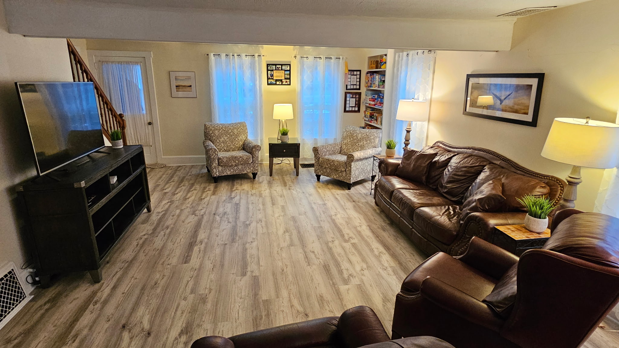 Large Living room with huge smart TV and comfy leather furniture.