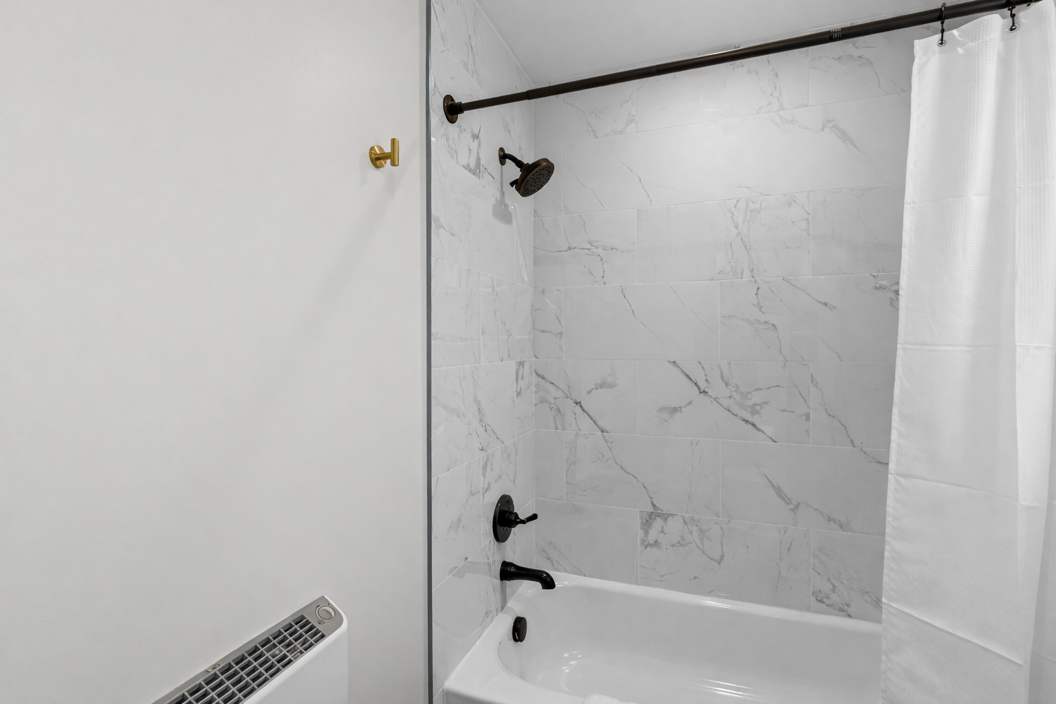 Sleek tub/shower combo with modern tile surround and contemporary fixtures—perfect for a refreshing rinse or a relaxing soak.