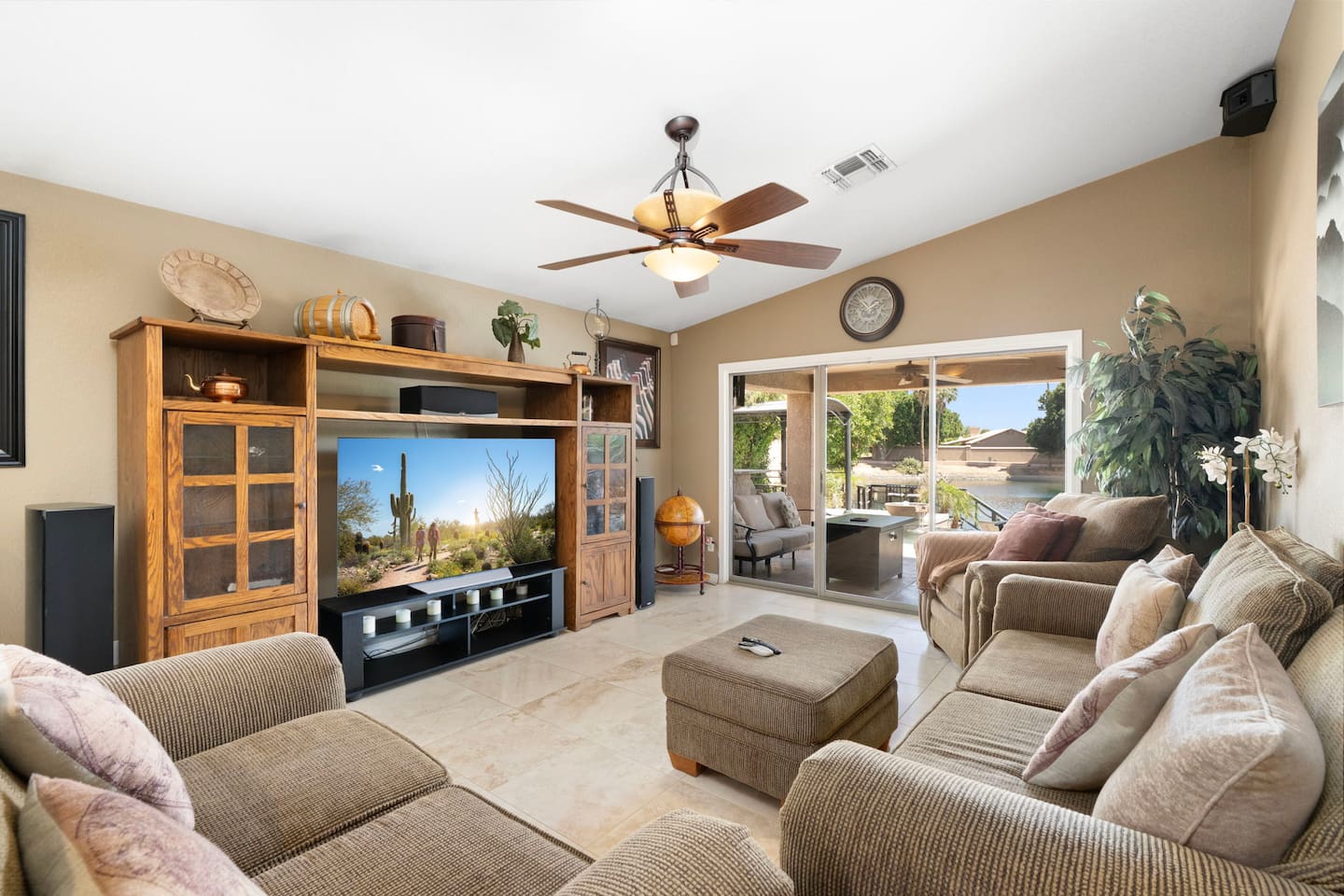 Spacious living room with plush seating, large-screen TV, and sliding glass doors opening to the patio and pool — your home base for relaxing after a day of exploring.