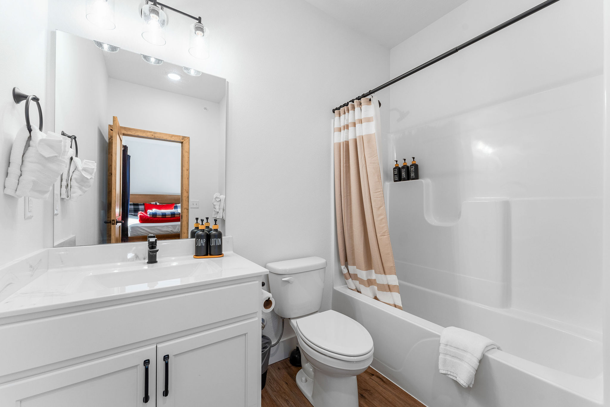 Bright full bathroom with a tub/shower combo, clean finishes, and fresh towels provided.