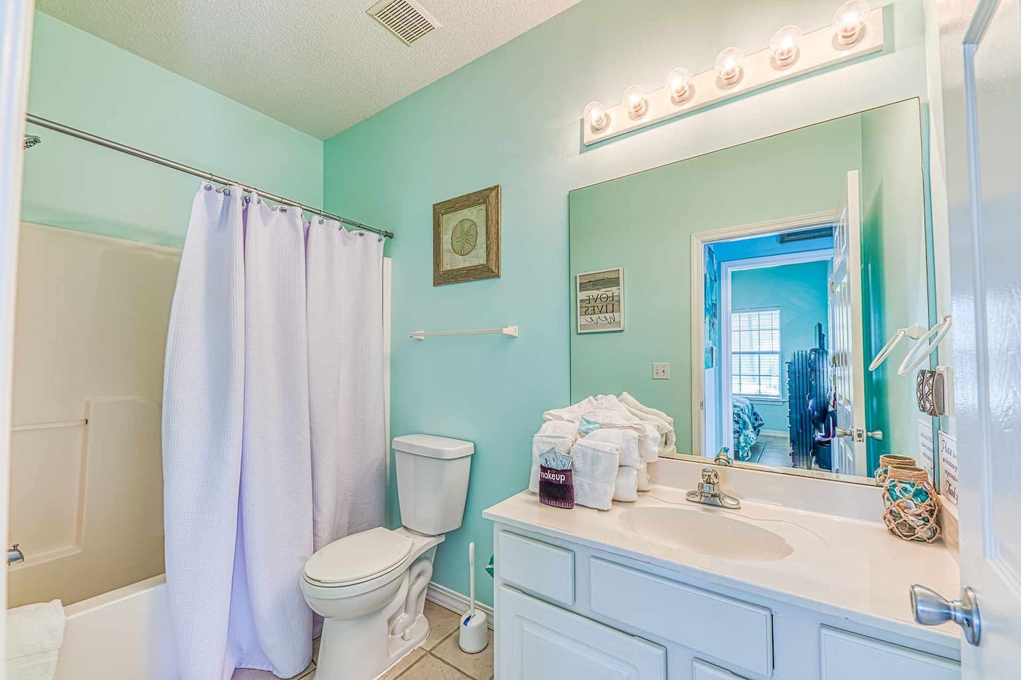 Bathroom: Refresh in a vibrant space with soothing hues and stylish decor! Perfect for beach days!