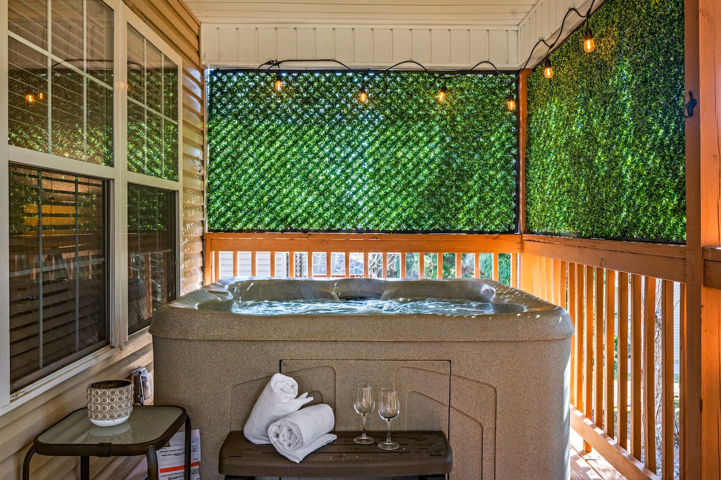 Enjoy your own private hot tub retreat, surrounded by lush greenery for added privacy. Perfect for relaxing after a long day, this cozy space features soft lighting, fresh towels, and even wine glasses for a peaceful soak under the stars.