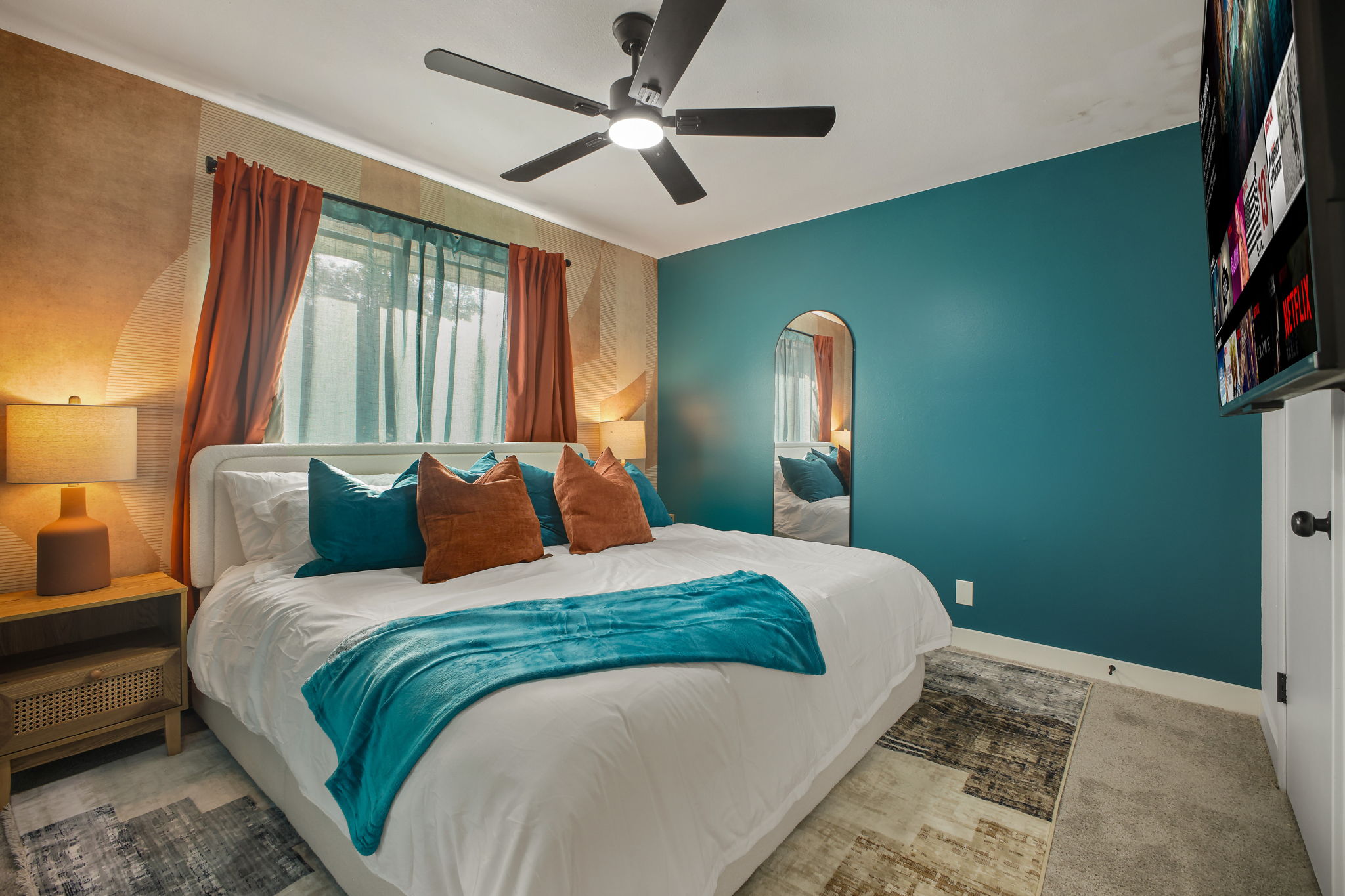 Bedroom 2: Colorful retreat with a king bed, bold accent walls, and a sleek Smart TV.