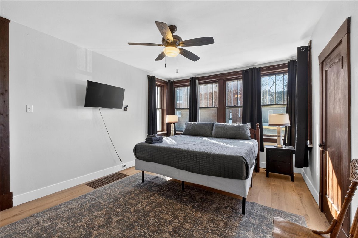 Cozy first-floor bedroom featuring a comfortable king bed, beautifully illuminated with many windows for a relaxing and enjoyable stay!