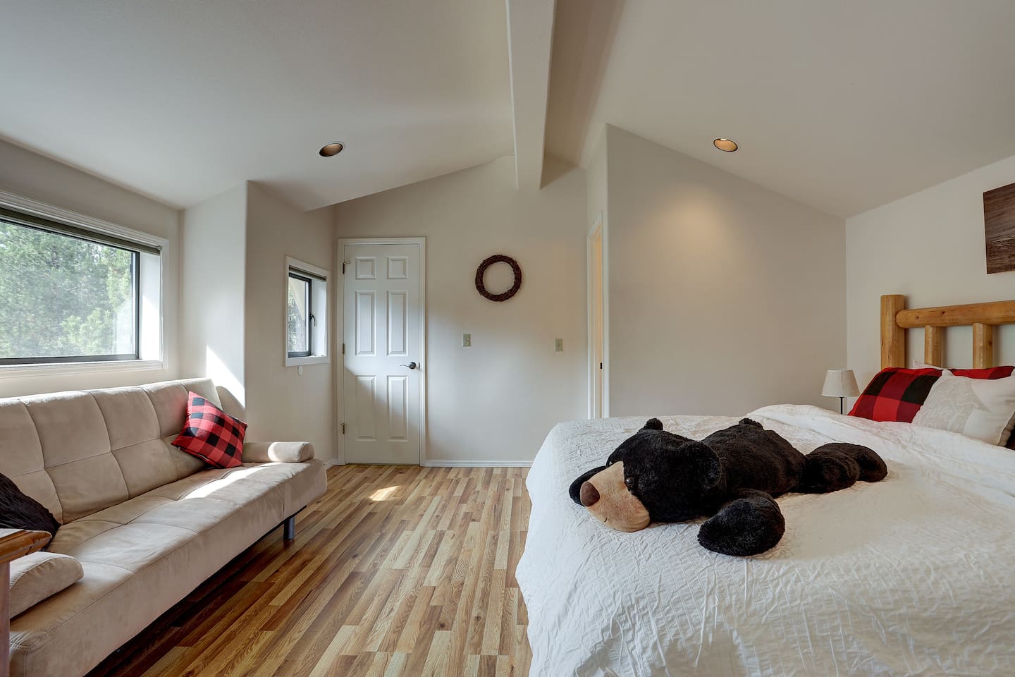 This large primary bedroom has plenty of space for a king bed plus a futon for lounging or extra sleeping space.  The two doors lead to a walk-in closet and an en-suite master bathroom. 